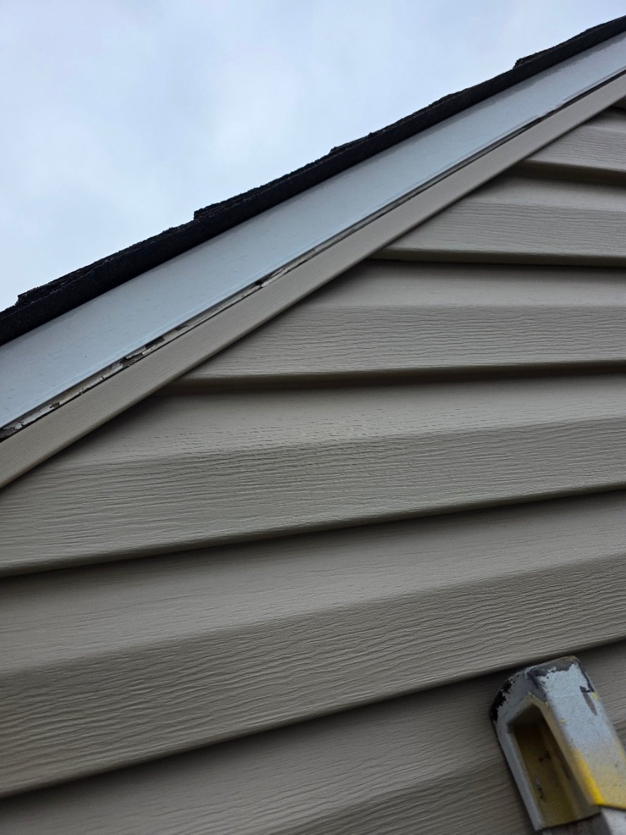 Roof edge and fascia transition showing a missing protective metal detail where water can migrate behind siding over time